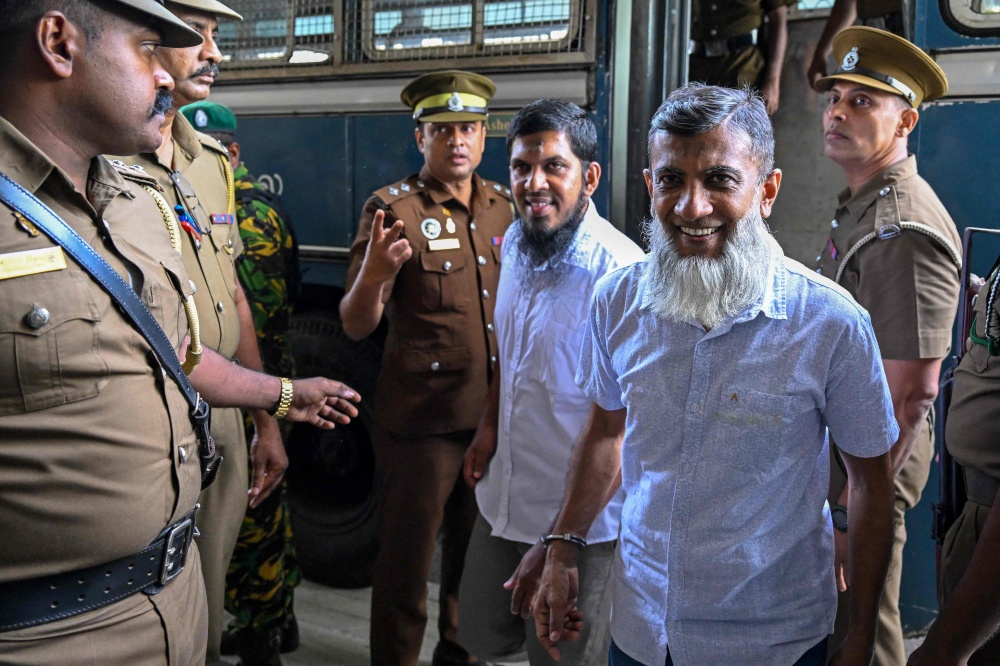 Police personnel escort the accused involved in Sri Lanka’s Easter Sunday attacks of 2019 during the verdict in the trial at the Colombo High Court in Colombo on September 22, 2026.