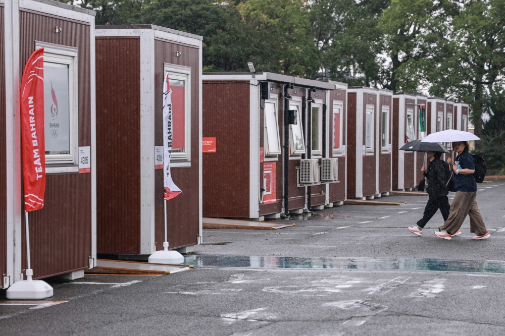Officials walks past temporary container huts during a press tour of the athletes’ village during the 2026 Asian Games at the Garden Pier in Nagoya September 27, 2026. — AFP pic