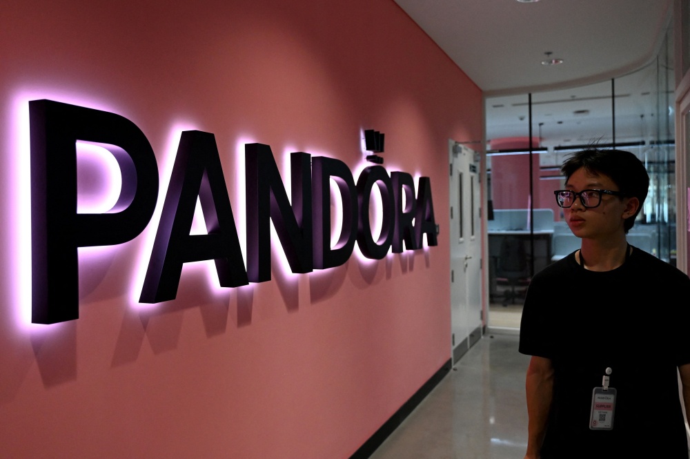 An employee walks past a logo at Pandora's new manufacturing plant in Ho Chi Minh City on October 1, 2026, as the world's biggest jewellery brand opened the facility it said will be able to produce up to 60 million pieces each year. — AFP pic