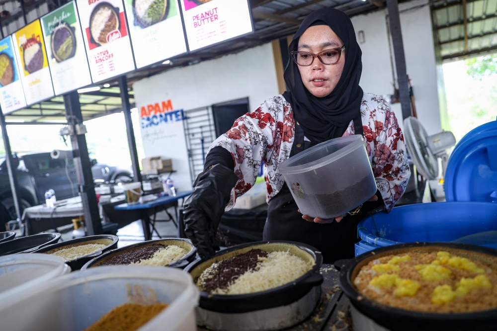 Nelta Efrida Zulfadhli prepares an ‘apam balik’ order at the Apam Balik Jalan Mawai shop. — Bernama pic