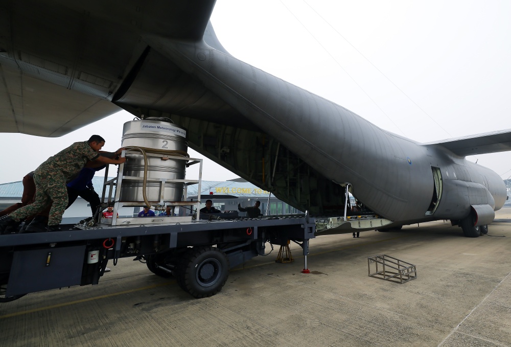 KUCHING, Sept 3 — Malaysian Army (TDM) personnel push tanks containing salt solution into a Royal Malaysian Air Force (RMAF) C-130 aircraft to carry out a cloud seeding operation at the RMAF Kuching Base today.