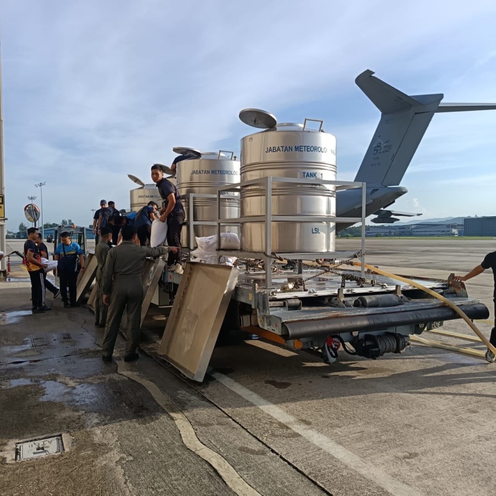 MetMalaysia personnel prepare a saltwater mixture for cloud seeding before loading the barrels onto an RMAF aircraft at the Subang airbase for operations in Perlis and Kedah on May 11, 2026. — Picture from Facebook/National Disaster Management Agency, Prime Minister’s Department