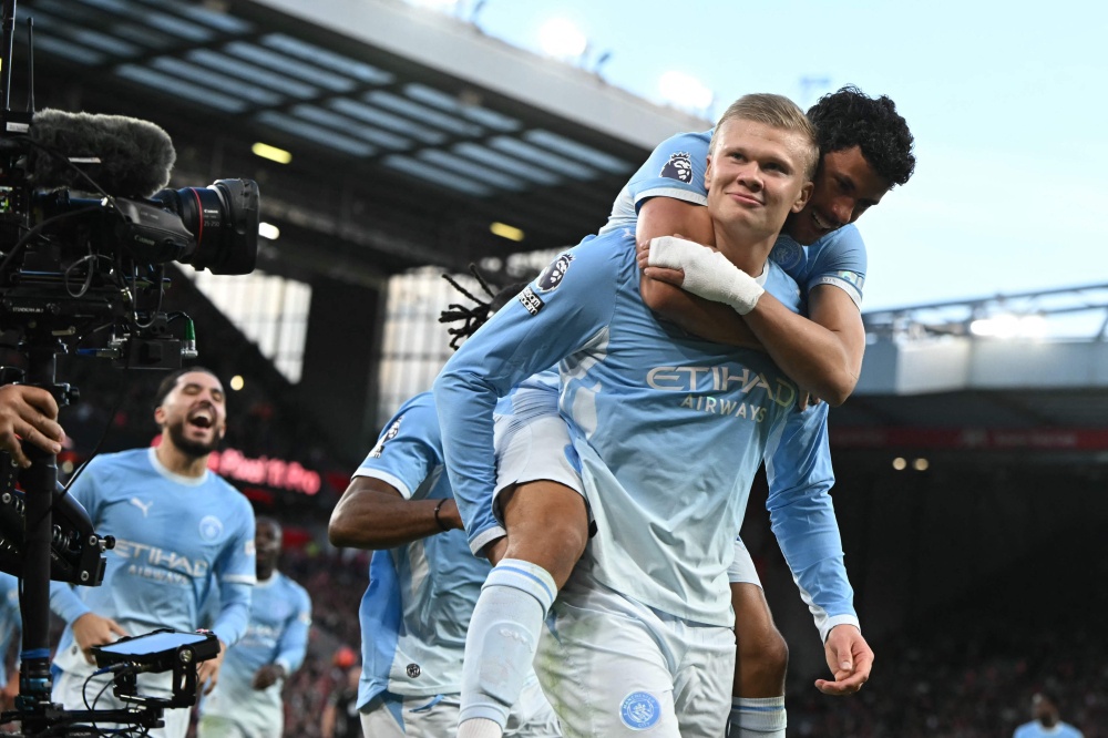 Manchester City striker Erling Haaland celebrates with teammate Matheus Nunes after scoring the opening goal against Liverpool during their English Premier League match at Anfield in Liverpool, England, on October 11, 2026. — AFP pic