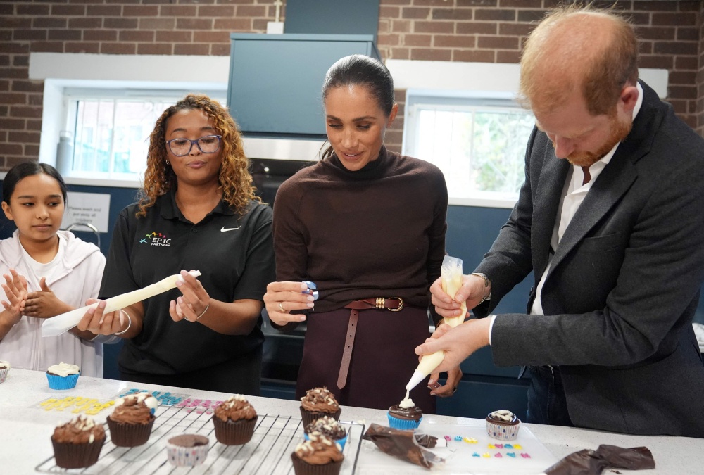 Britain’s Prince Harry, Duke of Sussex and his wife Meghan, Duchess of Sussex, decorate birthday cupcakes during a visit to Epic Partners in Nottingham October 15, 2026.