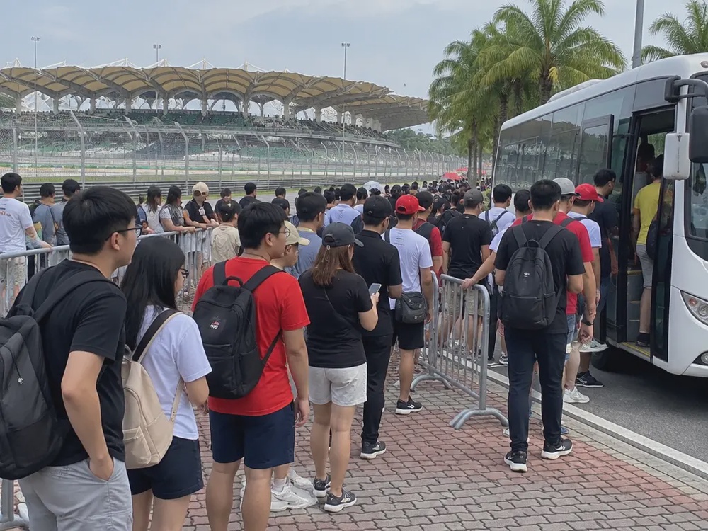 示意画面：赛车场出口的观众排成长队等候接驳巴士。