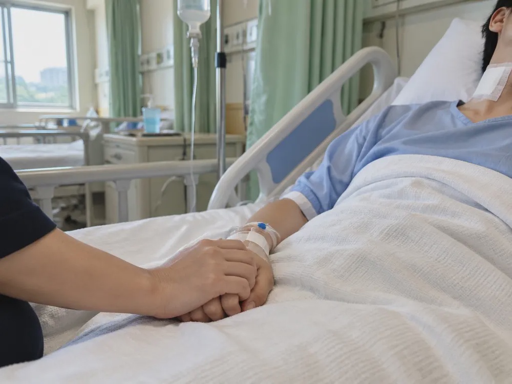 示意图:病床上颈部包扎的伤者,家属握着她的手