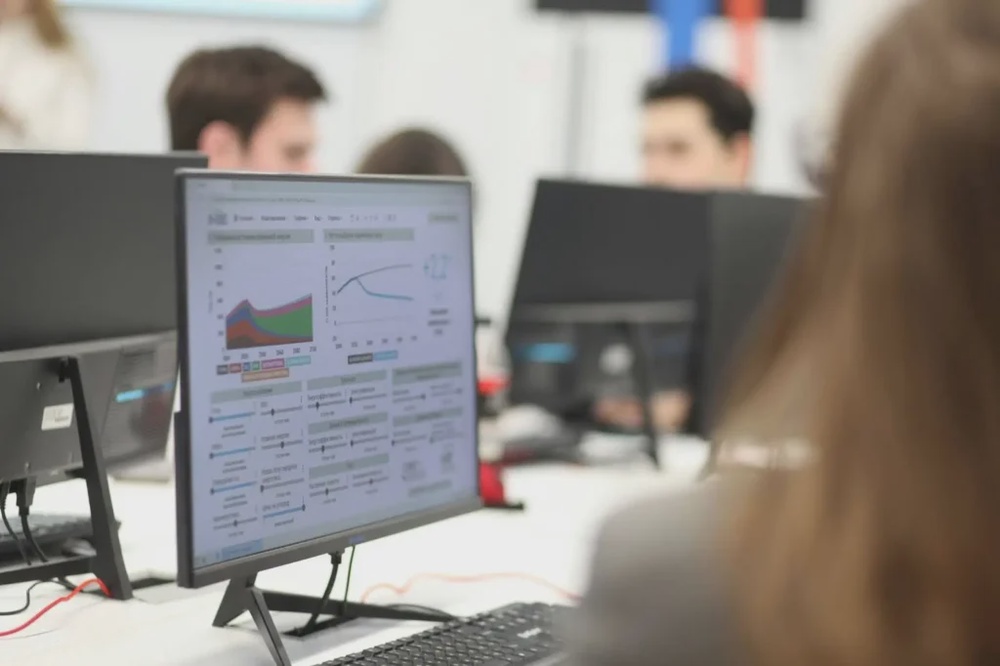 Team analysing data dashboards on computer screens, representing KPI tracking and performance monitoring in software projects.