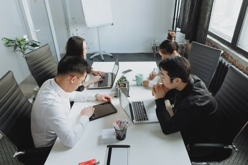 Team collaborating with laptops and tablets, representing enterprise software planning and web application development decisions.