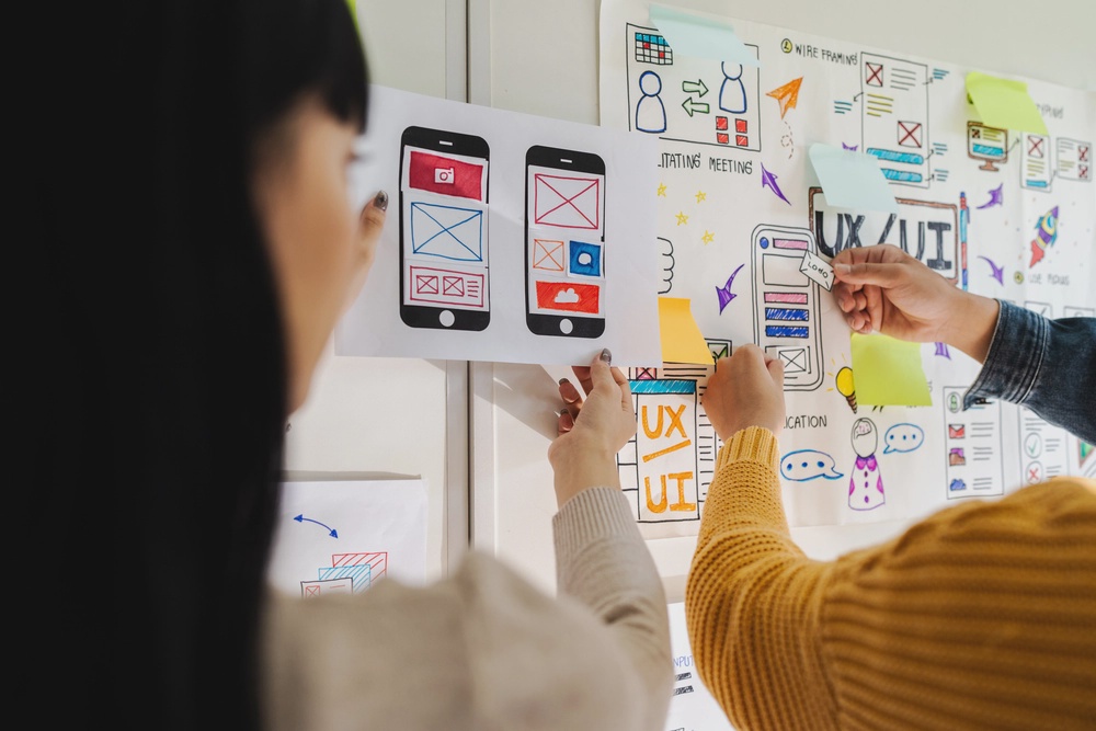A girl and her teammate creating an app design architecture to give a intuitive user experience with attractive design.