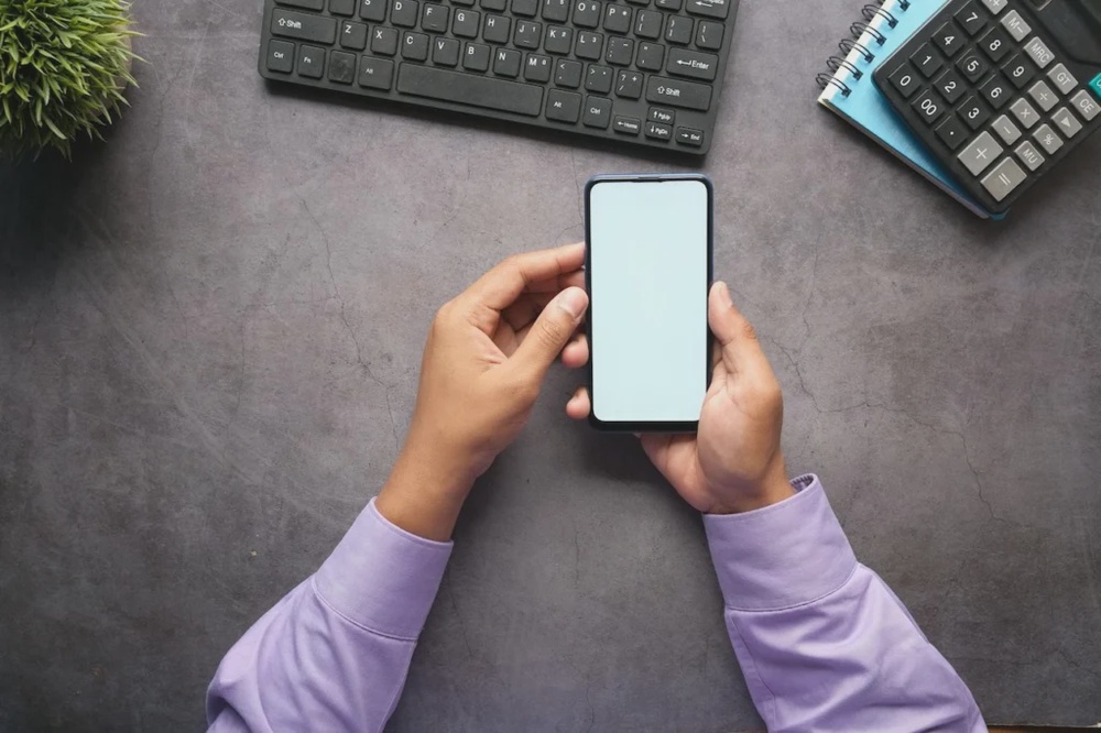 Flutter e-commerce app development concept with smartphone on desk.