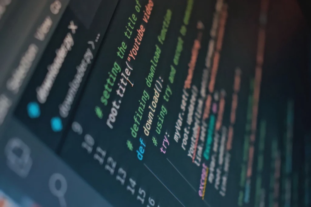 Close-up of programming code on a dark screen, showing a script for downloading a YouTube video.