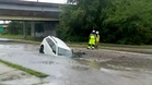 Woman rescued after car plunges into flooded sinkhole