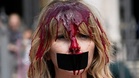 Activists covered in red paint protest bullfighting in Pamplona