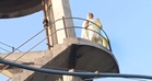 Woman climbs water tank over alleged police inaction, brought down after hours of talks