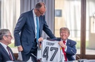 Muted reaction from Trump as Merz gifts him German team jersey at G7
