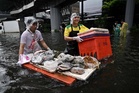 In kayaks or waist-deep in floodwater, shoppers return to Bangkok markets