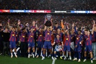 Watched by its grieving coach, Barcelona retains Spanish league title by beating rival Real Madrid