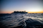 Aid group says Libyan-linked vessels fired on a migrant rescue ship in the Mediterranean