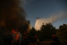 Photos show destruction from wildfires in Greece as blazes take hold in Europe and parts of the US
