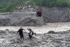 Trading food for medicine and crossing the river by zip line are part of life in Nepal flood zone