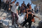 Photos show rescuers recovering bodies after strike-damaged building collapses in Gaza