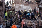 Locals and rescuers clear the rubble of a residential building destroyed in a Russian missile strike, in photos