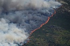 Firefighters race to stop wildfires merging near Madrid