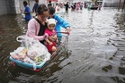 In kayaks or waist-deep in floodwater, shoppers return to Bangkok markets