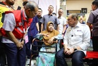 Disabled woman braves drizzle on three-wheeler for chance to meet Anwar in Seremban