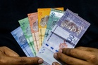 Ringgit opens stronger against US dollar, but Fed caution keeps gains in check