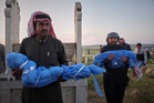 A grieving father buries his 6-year-old after a land mine kills 3 children in Syria's Idlib