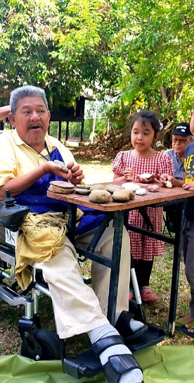 Image from: Deen an OKU once charged to be certified as one, now out on his motorised wheelchair teaching art #TheGoodOKU