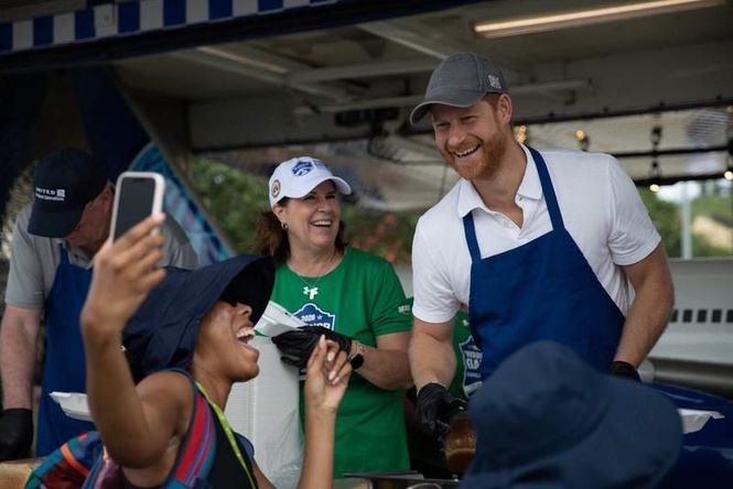 Image from: Harry pictured serving barbecue in apron and gloves as royals unite on Palace balcony