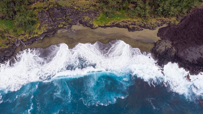 Image from: On Réunion Island, this wild black-sand beach shaped by lava flows offers a spectacular volcanic landscape