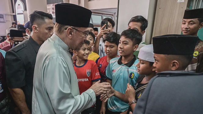 Anwar (kiri) beramah mesra dengan jemaah sebelum menunaikan solat Jumaat di Masjid Al-Muqarrabin, Bandar Tasik Selatan hari ini.  --fotoBERNAMA