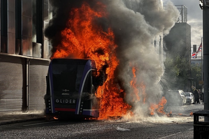 Bus set alight by masked protesters as violence flares following stabbing attack