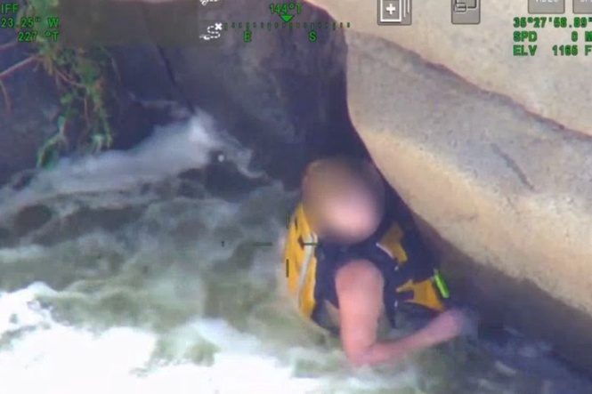 Dramatic rescue after woman found clinging to underside of cliff amid raging torrents of California river