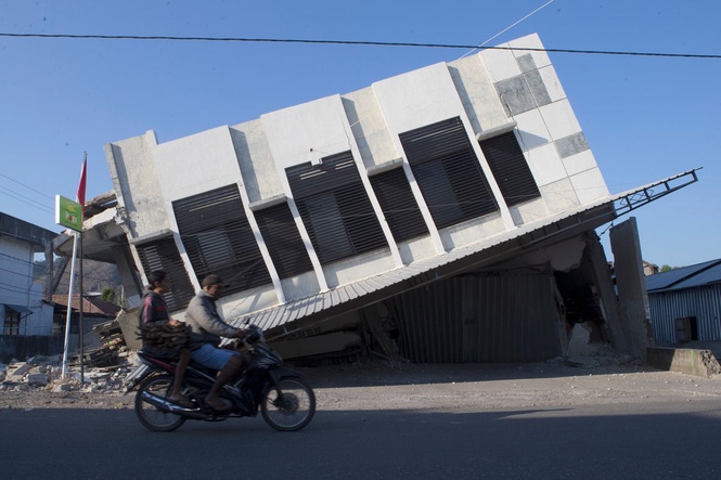 People await aid after powerful earthquake in Indonesia, in photos