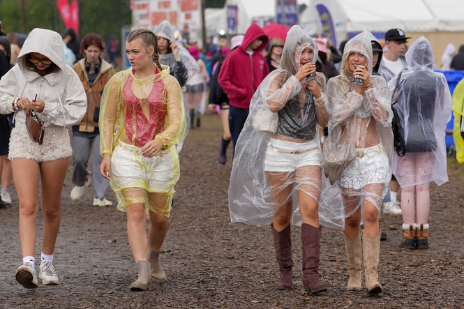 Festivalgoers braving rain and mud as thunderstorm warning in force