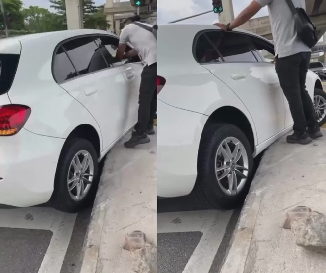 Image from: Strangers step in to help woman after car gets stuck on road divider